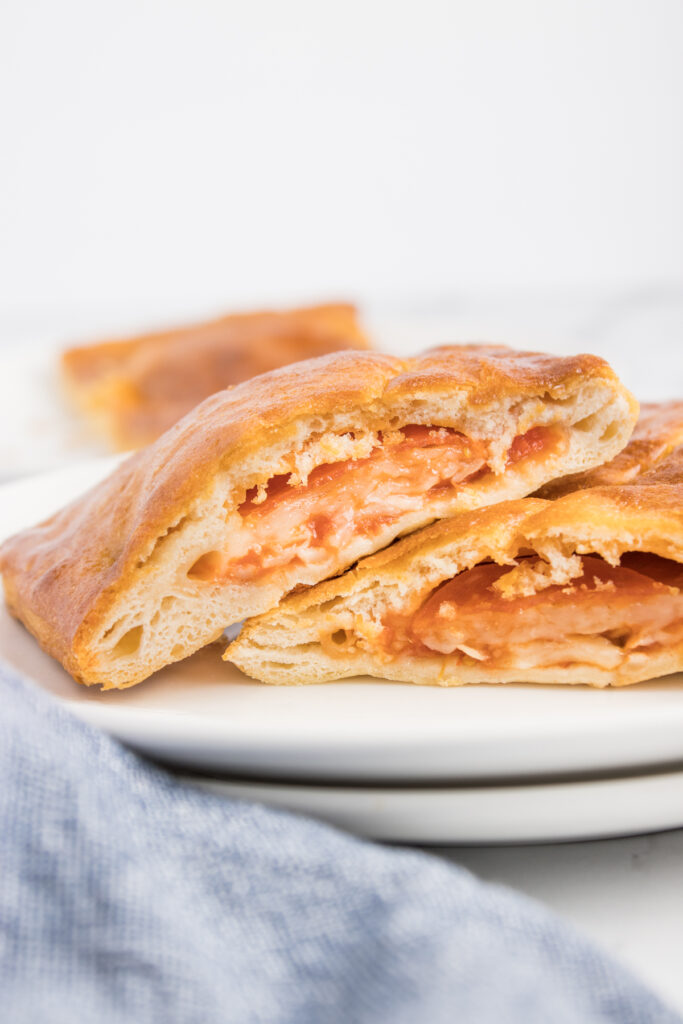 The image shows hot pockets placed on a plate, cut in half to reveal their contents. The inside of the hot pockets is visible, displaying the delicious fillings they contain.