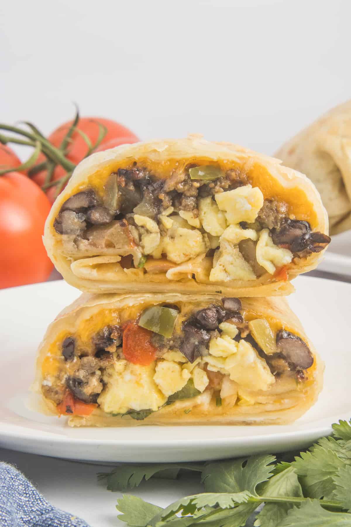 The image displays a stack of air-fried burritos. One of the burritos has been cut in half to reveal its contents.