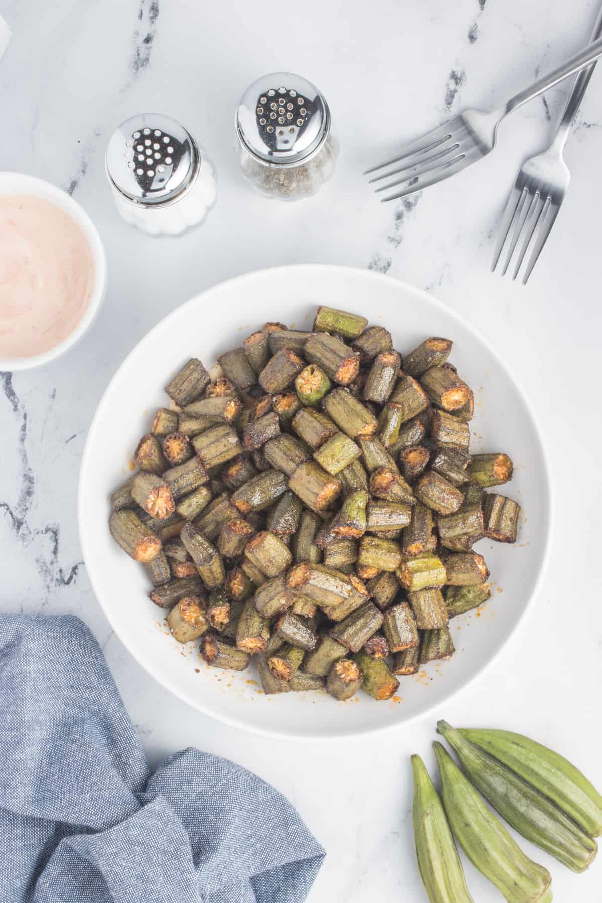 The image depicts cooked okra on a plate. The okra has been cooked to a deliciously crispy and tender texture, making it an inviting dish ready to be savored.