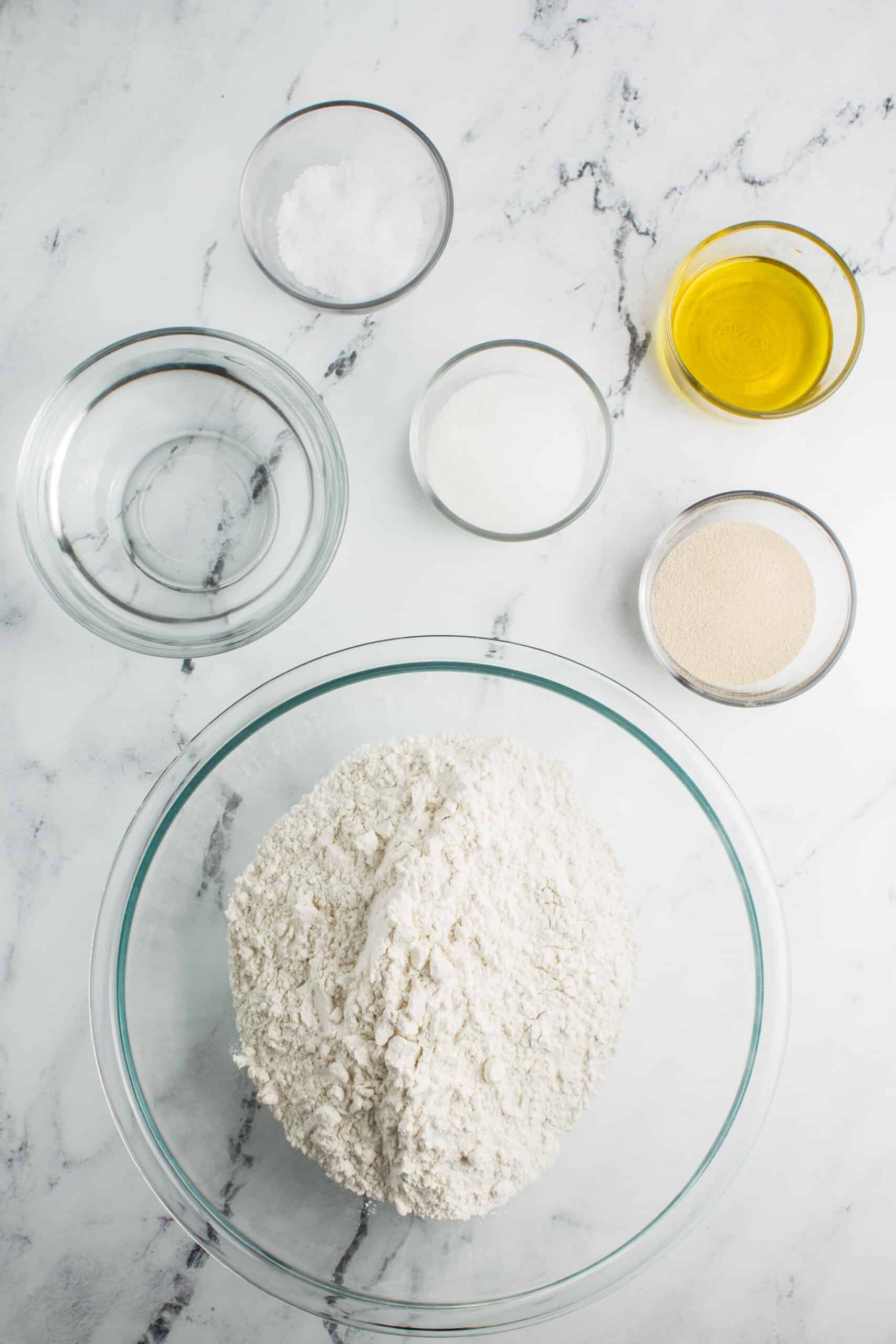 This ingredient shot features flour, salt, sugar, water, yeast, and oil, showcasing the essential elements used in the homemade sandwich bread recipe.