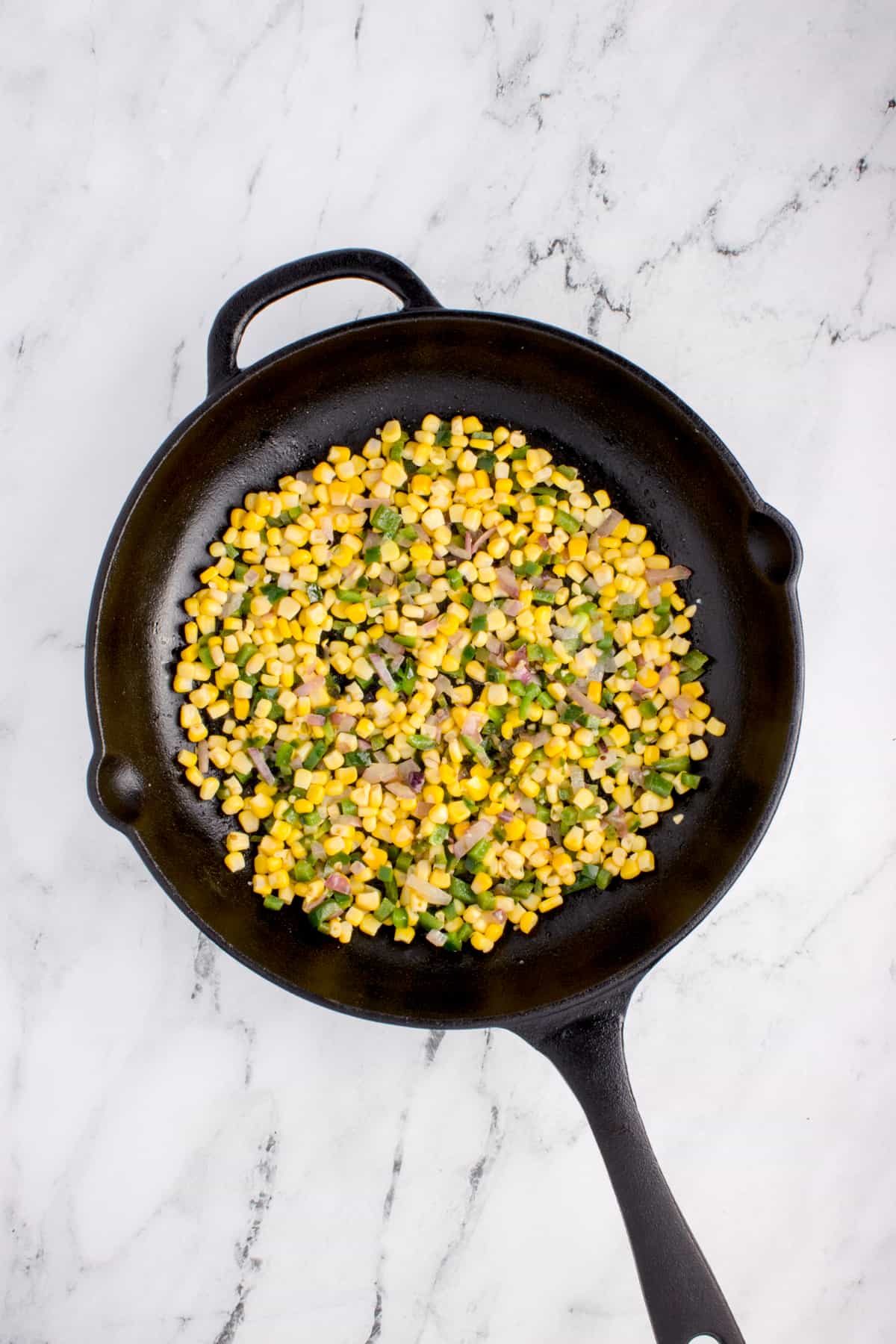 Cast iron skillet with corn, peppers, and onions