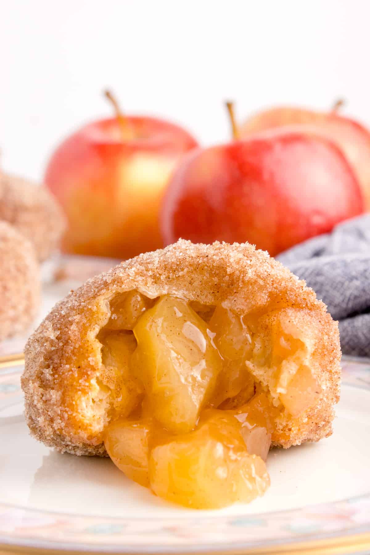  The image depicts an air fryer apple pie bomb that has been partially bitten into, revealing its luscious apple filling inside.