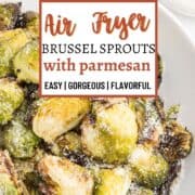 Crispy Brussel sprouts in a white dish, dusted with parmesan cheese.