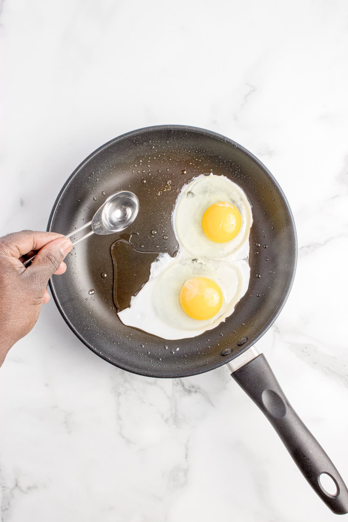 Water being poured into a pan with eggs in it.