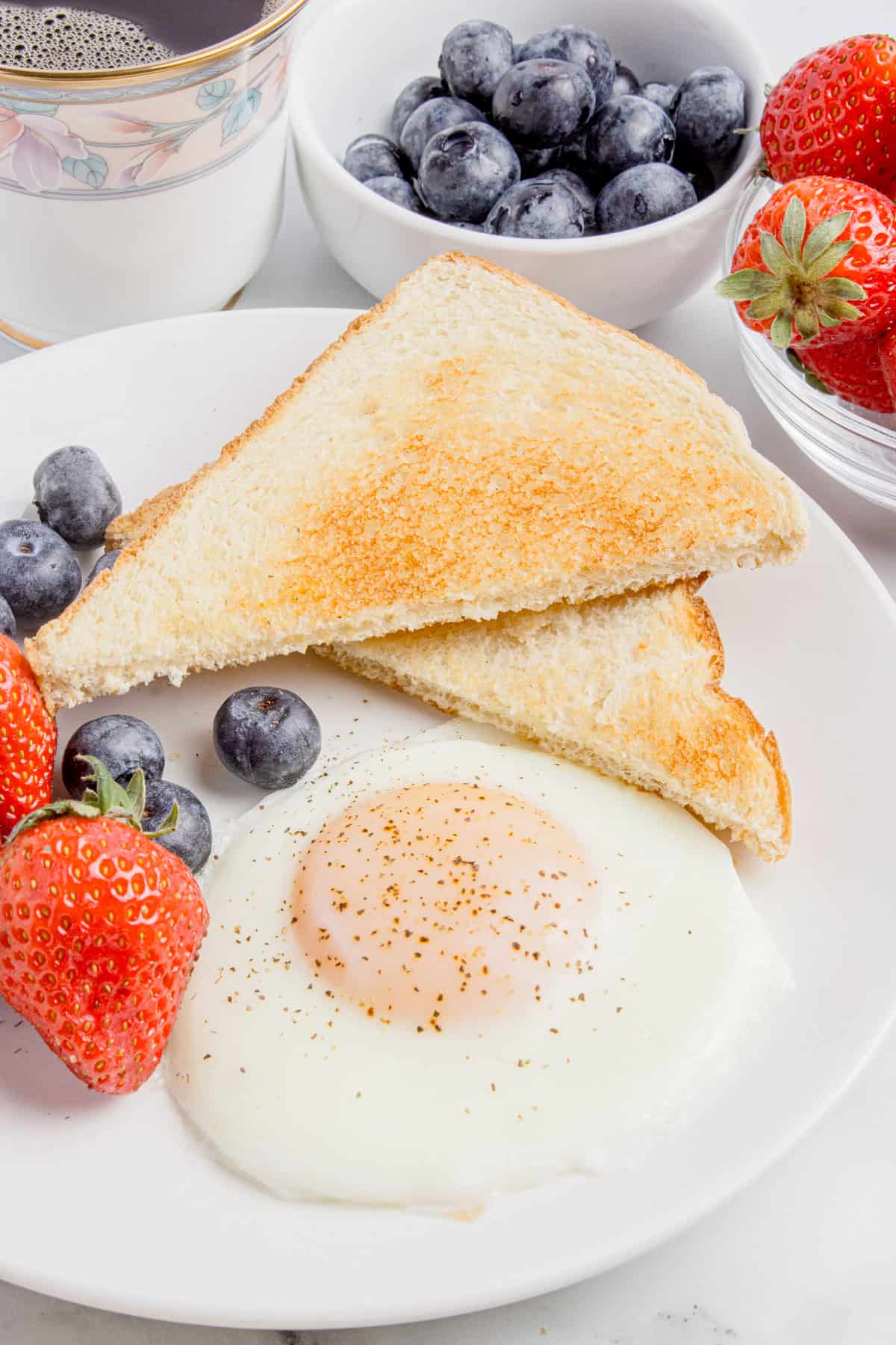 Eggs over easy with a plate with fruits. 