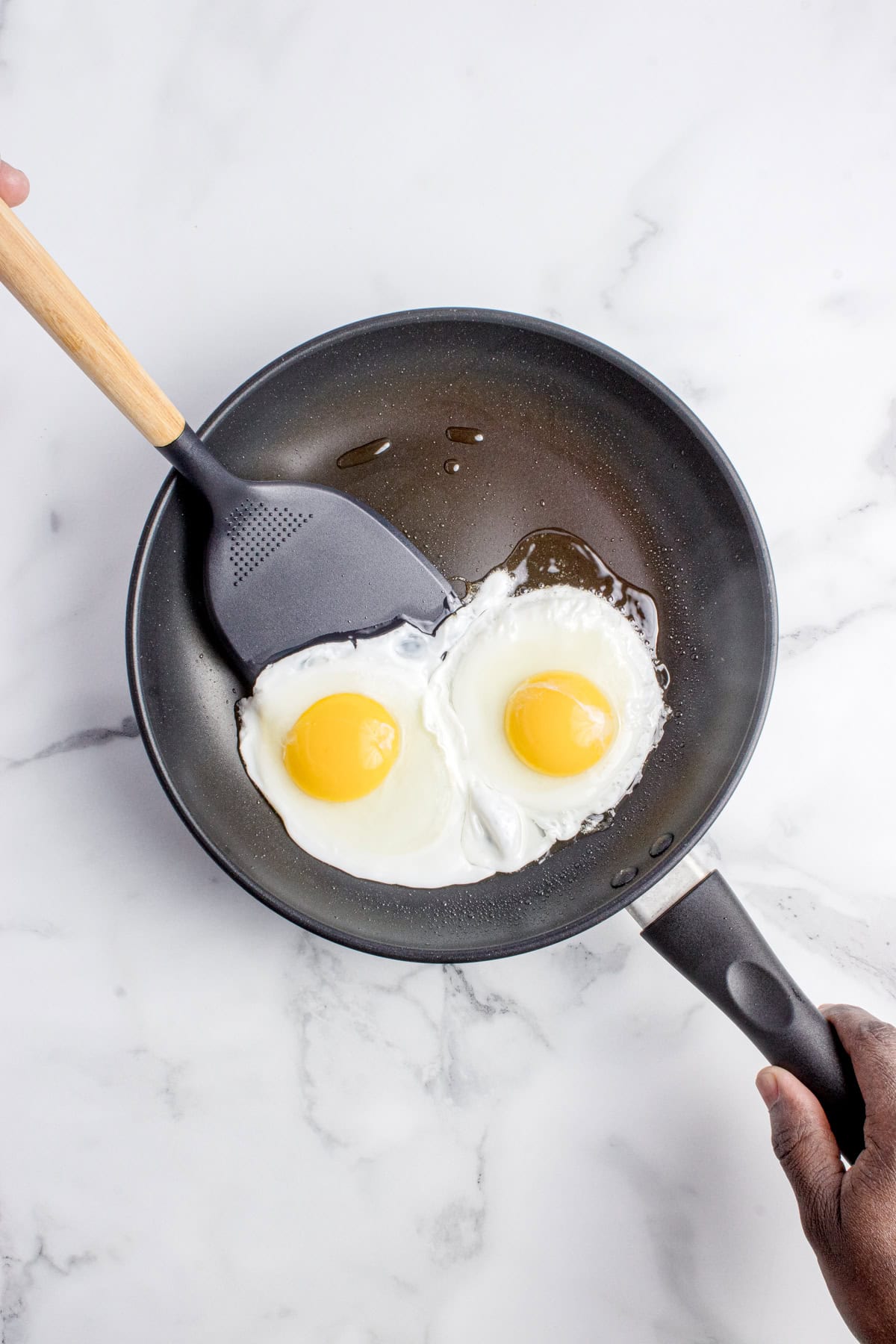 Spatula about to flip the eggs