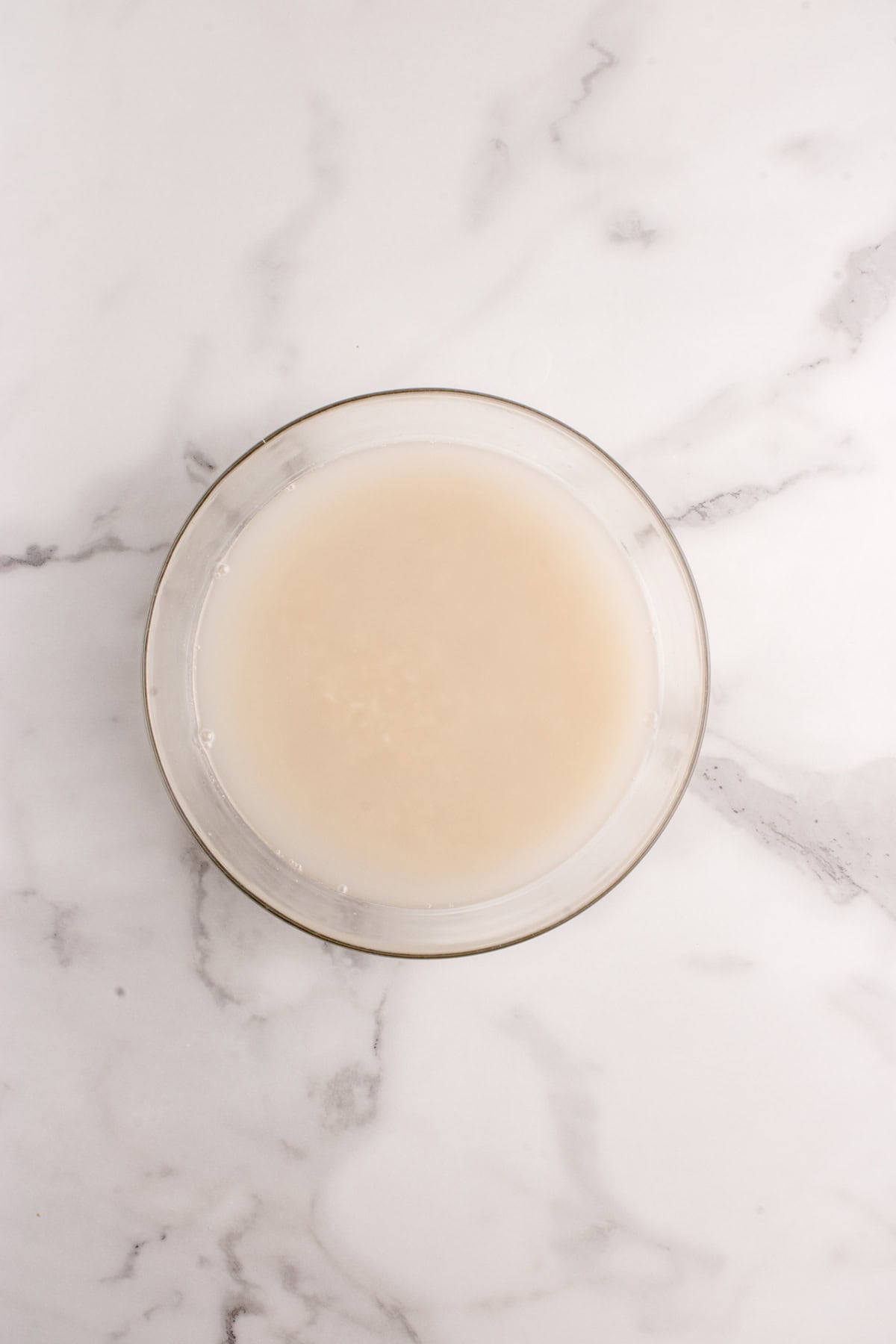 Rice in a bowl with water. The water is cloudy