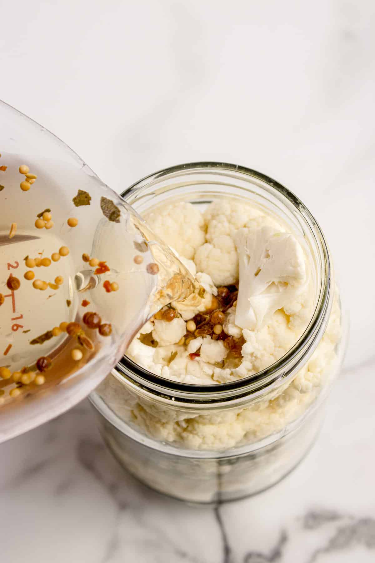 Brine being poured into the jar