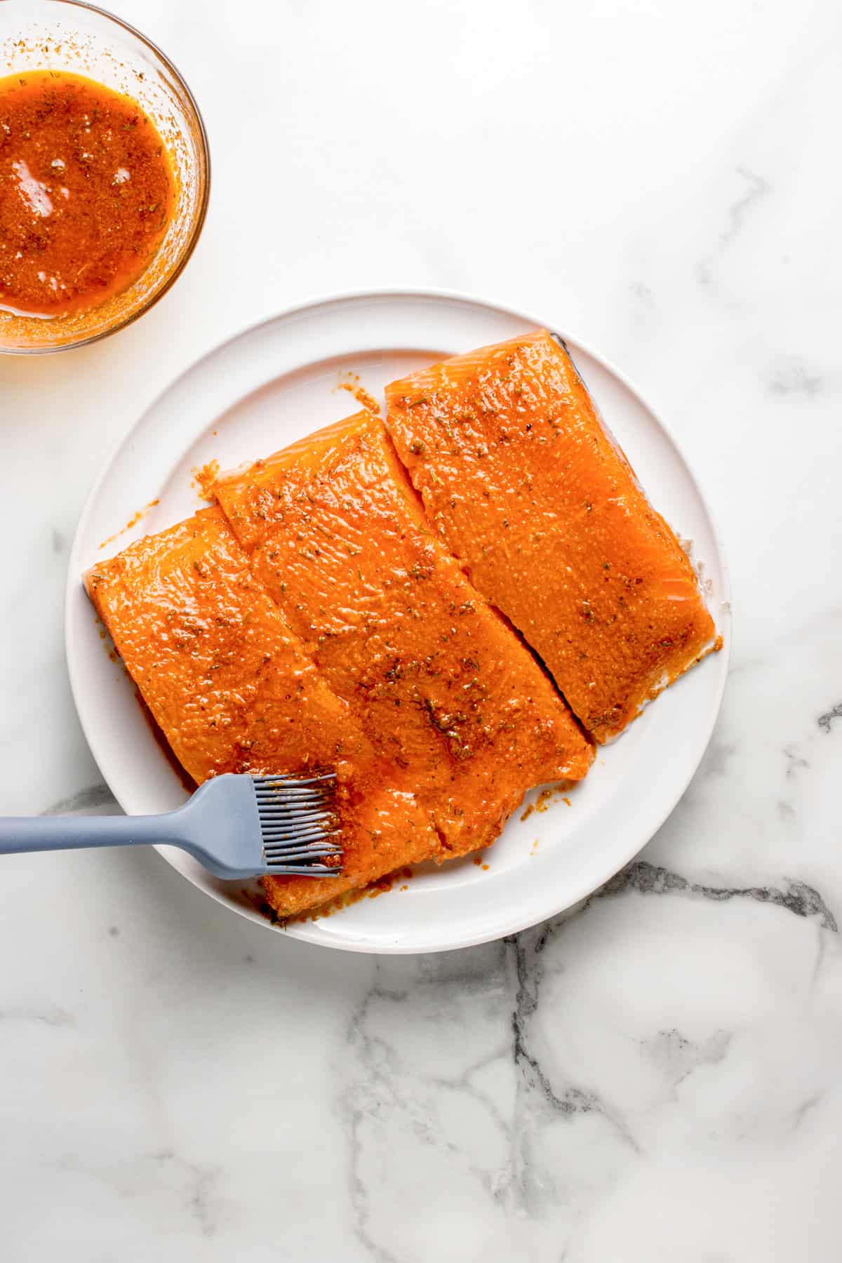 Marinade being brushed on the salmon.