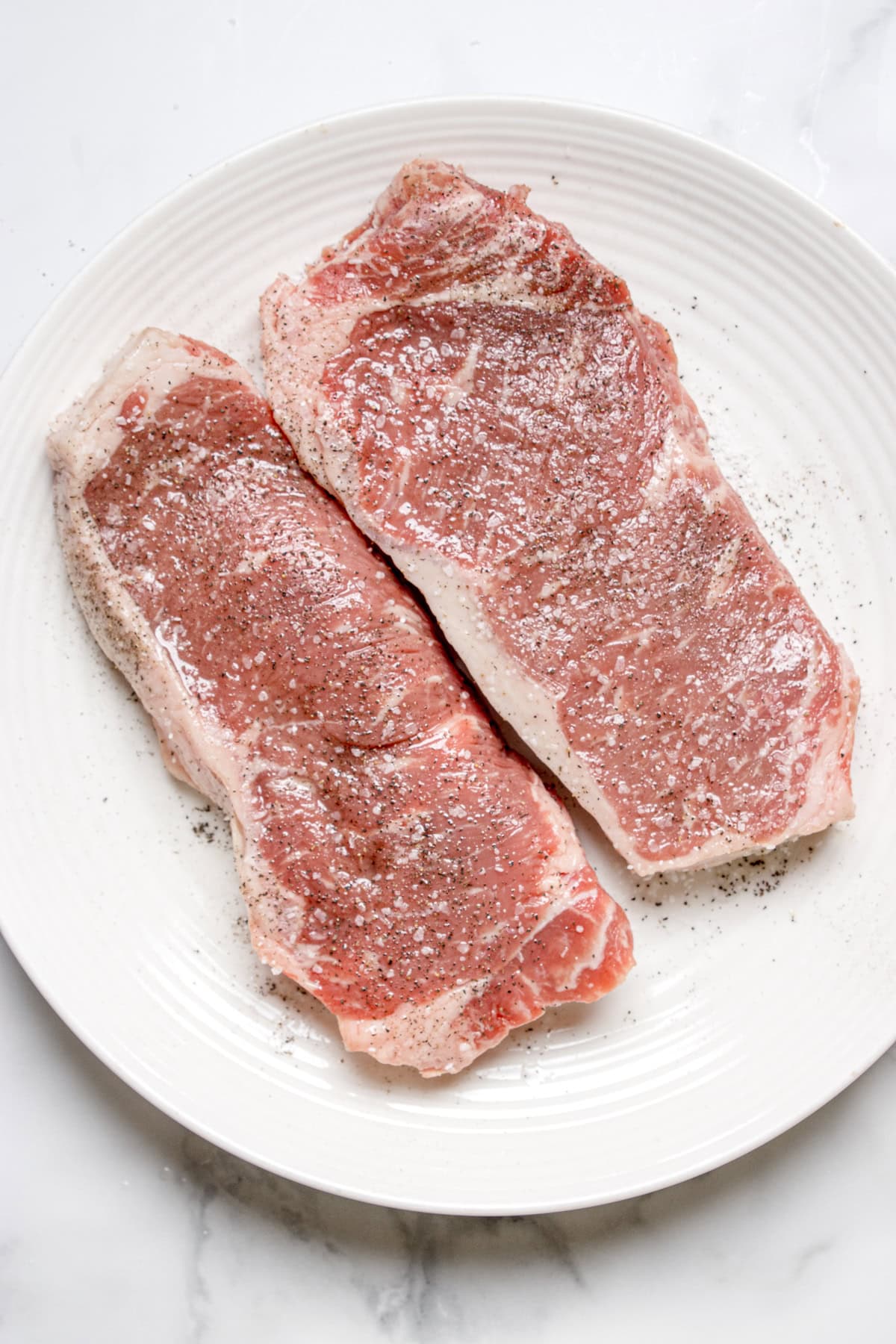 The two steaks seasoned with salt and pepper