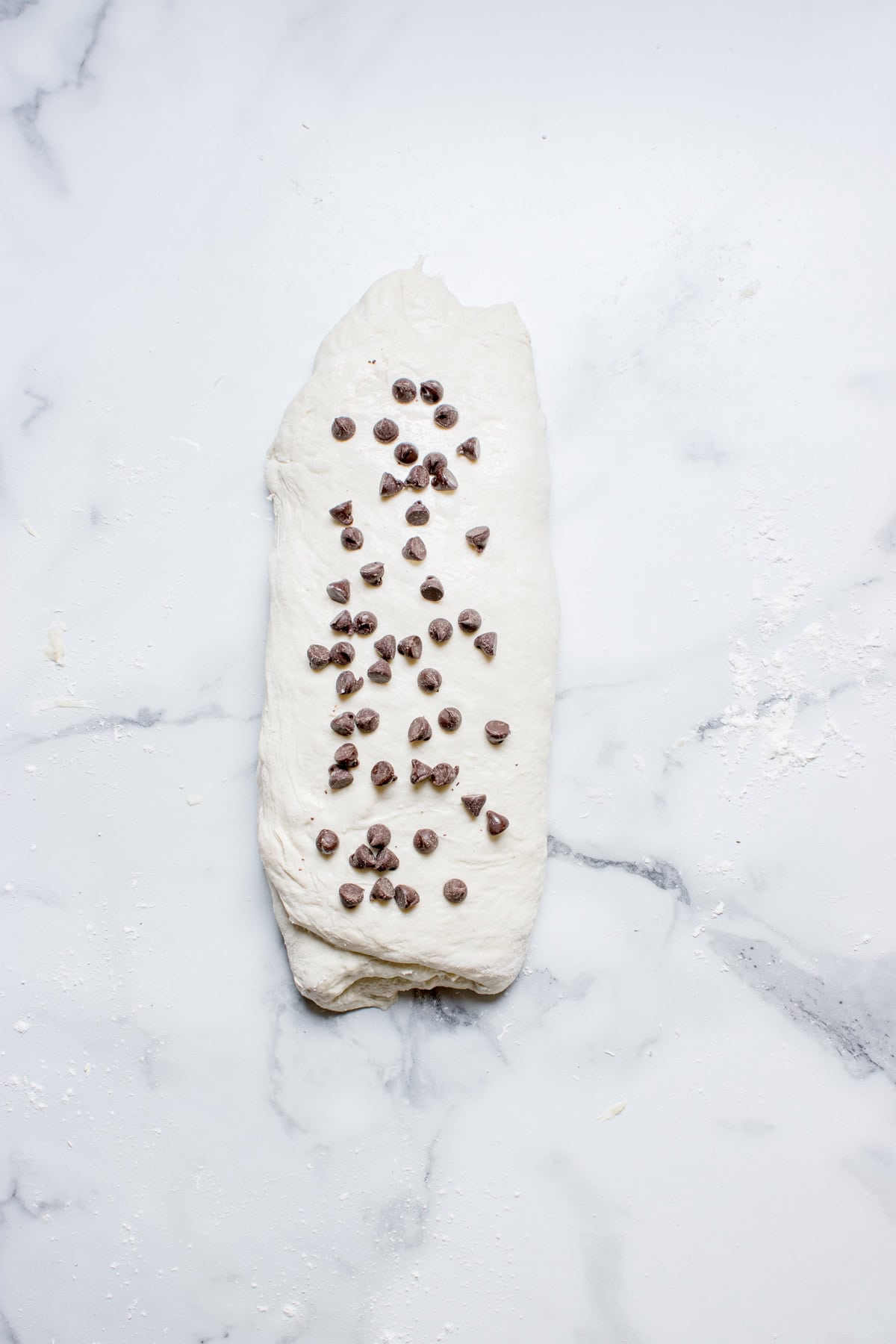 Rolled dough with chocolate chips on it.
