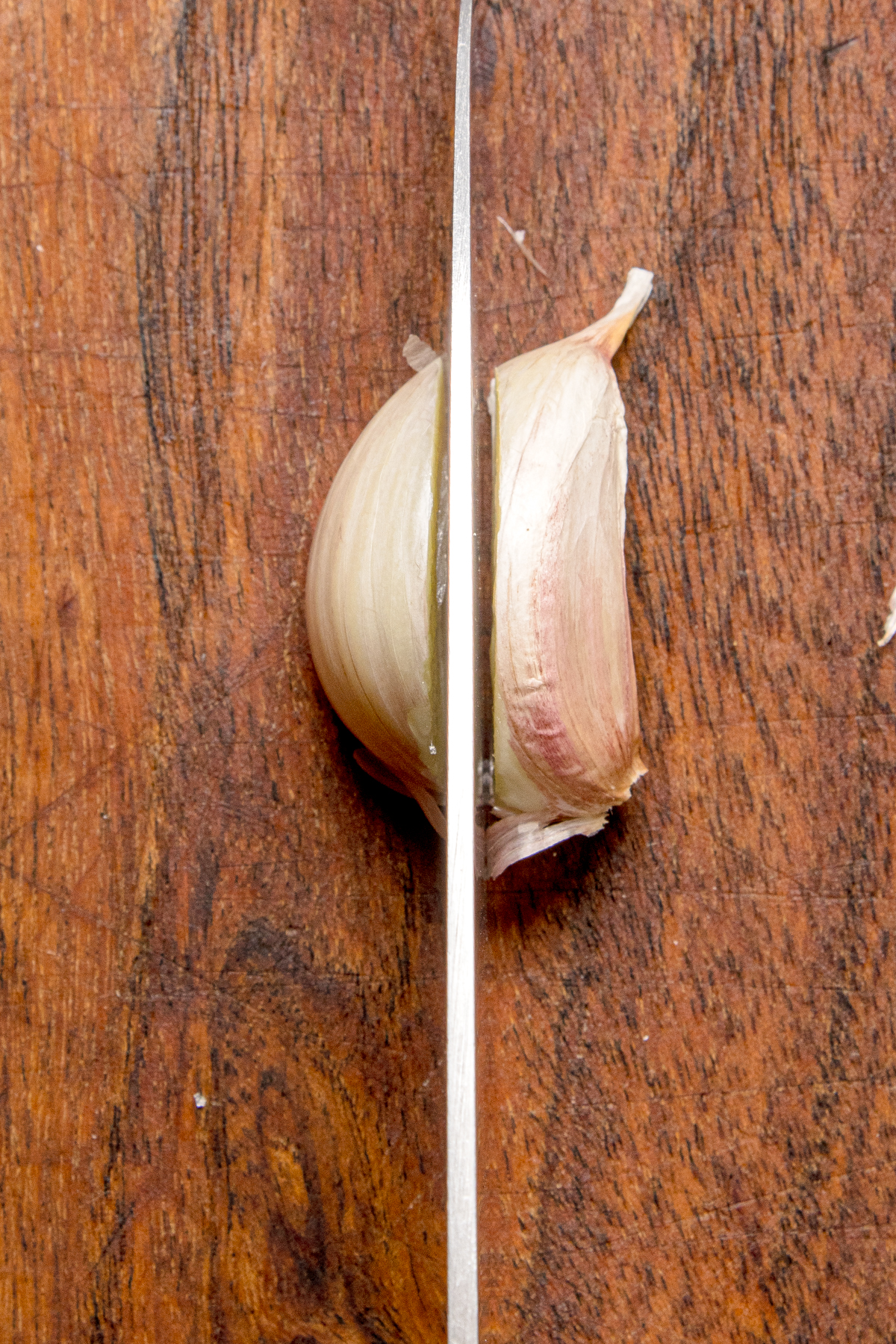Knife slicing a clove