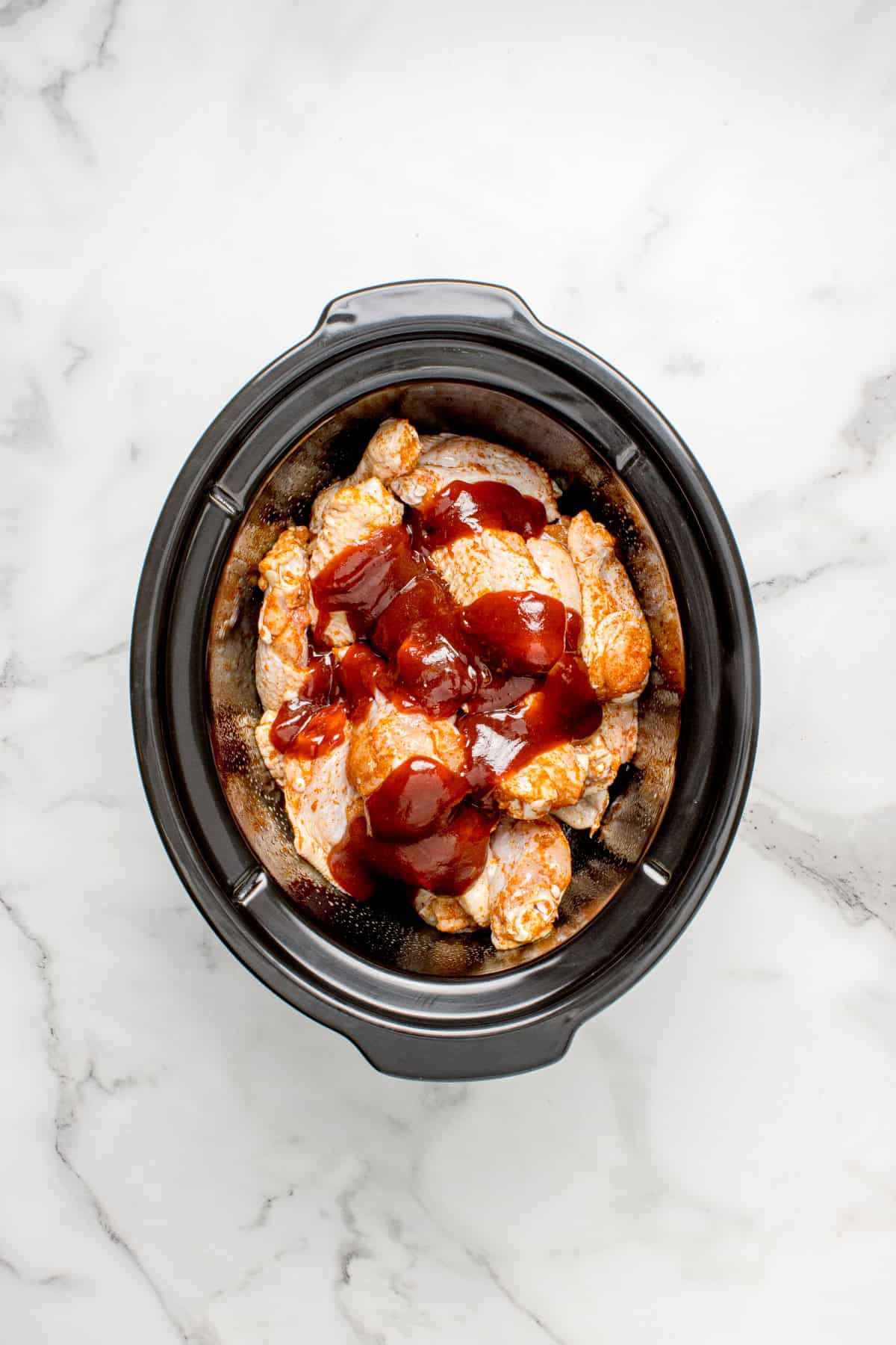BBQ sauce over wings in a slow cooker