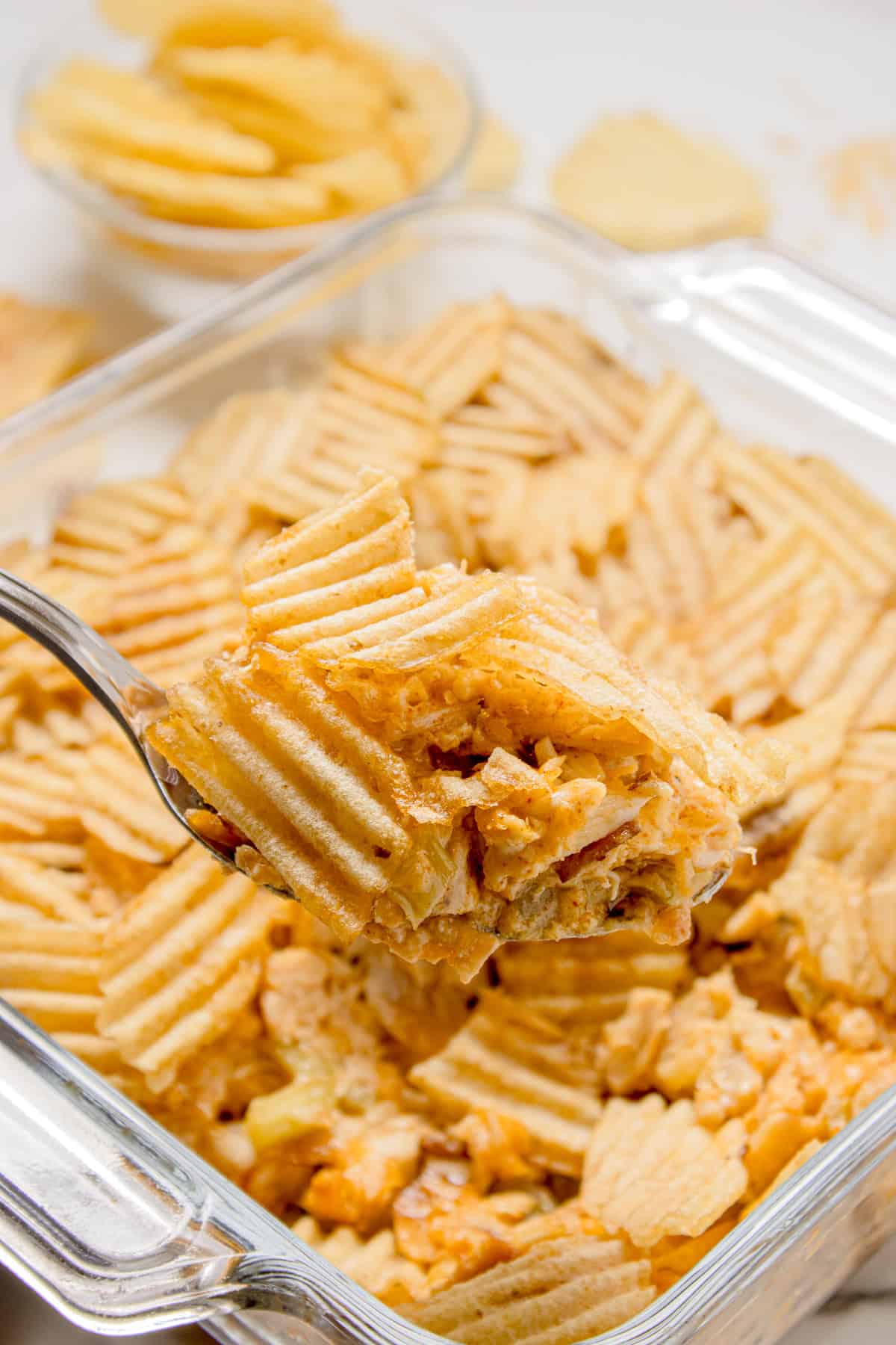 A spoon full of hot chicken salad casserole
