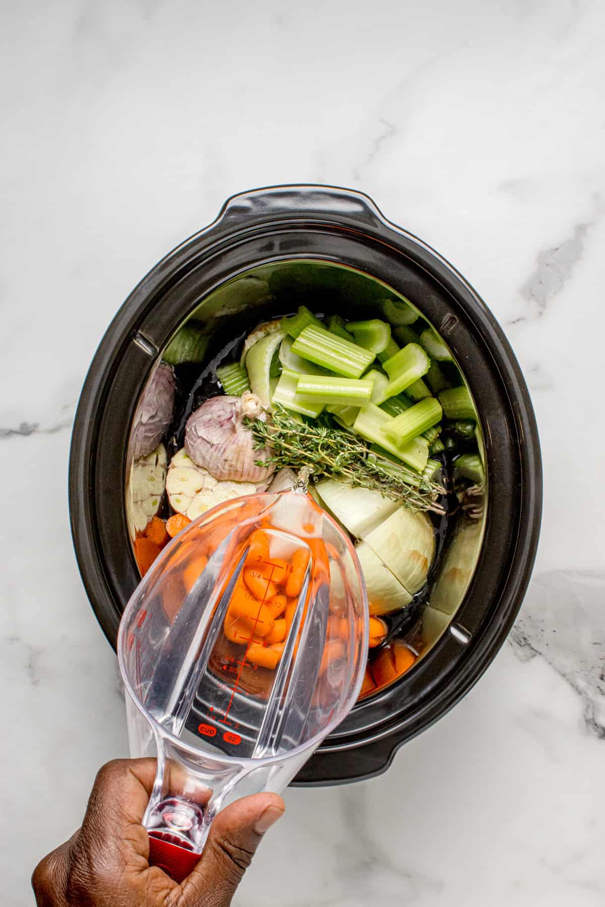 Pouring water in the slow cooker. 