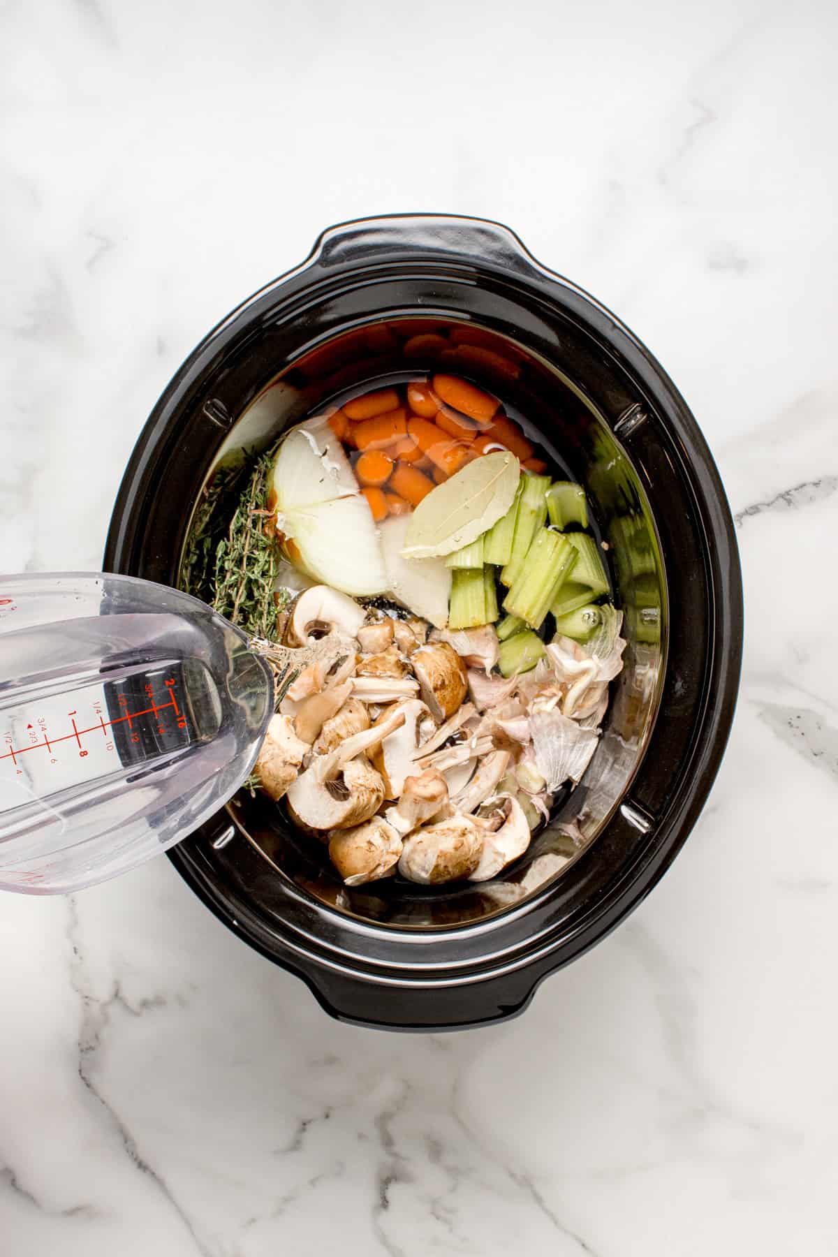 Water being poured into a slow cooker